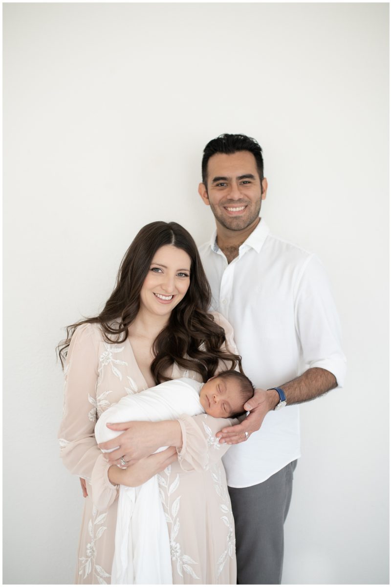 Mom and dad holding baby at a newborn studio session
