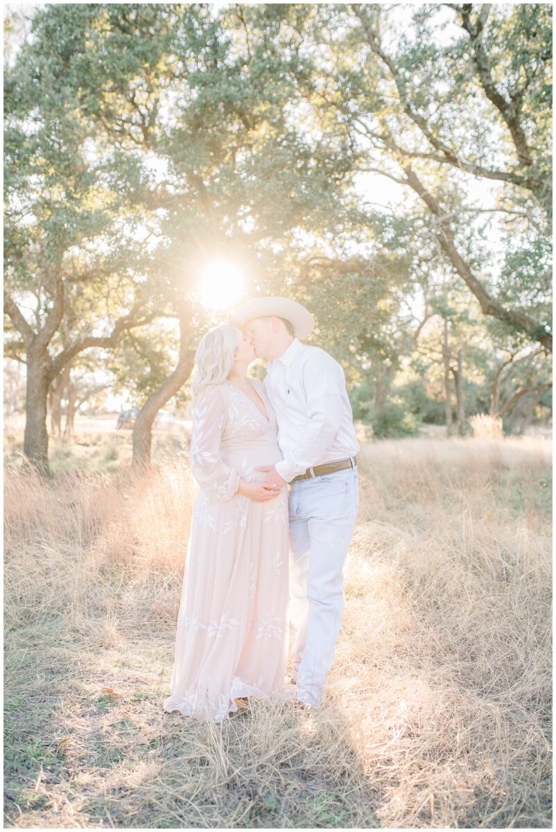 outdoor sunset maternity session in grassy field in with oak trees in Austin Texas