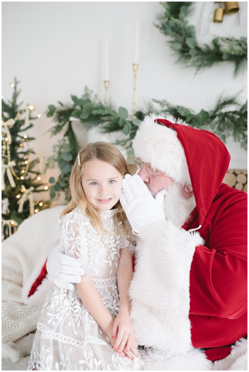 santa telling secrets to little girl best santa photos in austin